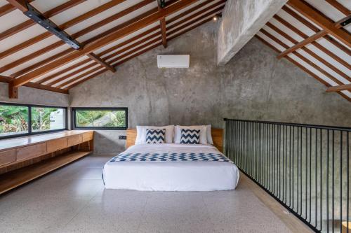 a bedroom with a large bed and windows at Sola Villa Ubud in Ubud