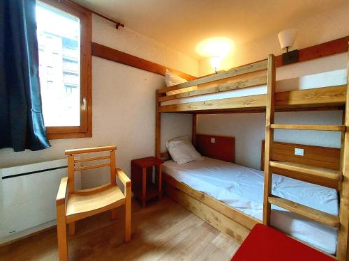 - une chambre avec 2 lits superposés et une chaise dans l'établissement Charmant 2P rénové avec balcon, proche commerces, casier à ski et parking, Plagne 1800 - FR-1-351-160, à La Plagne Tarentaise