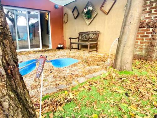 une cour pleine de feuilles avec un arbre et un banc dans l'établissement Au Ch'ti Cosy, à Roubaix