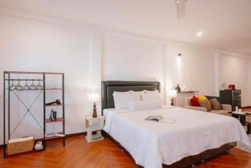 a bedroom with a large white bed and a living room at CBD Studio3 next to Sun Plaza Real City Center! in Medan