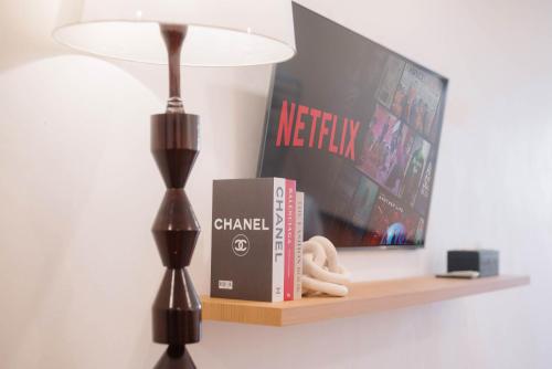 a lamp and books on a shelf with a tv at CBD Studio3 next to Sun Plaza Real City Center! in Medan