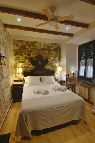 a bedroom with a large bed with a stone wall at Pensió Bellmirall in Girona