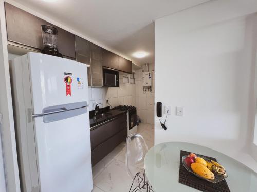 a white refrigerator in a kitchen with a bowl of fruit at Aquarius Residence Praia de Iracema in Fortaleza