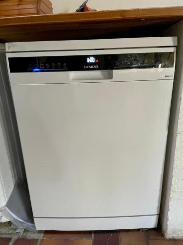 a white dishwasher sitting under a counter at Historisches Reetdach-Haus - bis zu 21 Personen in Großefehn 