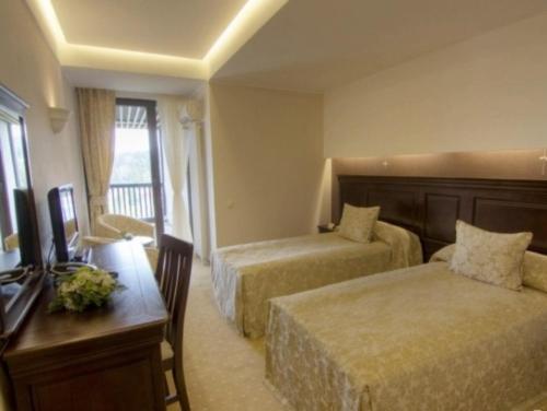 a hotel room with two beds and a desk at Alpin ApartHotel 2302 in Poiana Brasov