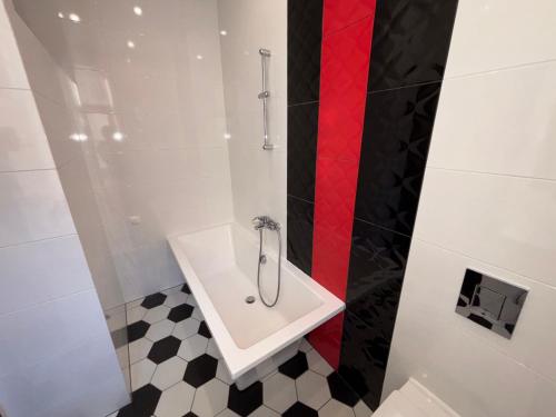 a bathroom with a sink and a red stripe on the wall at ApartHotel Riga in Rīga
