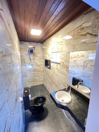 a bathroom with two sinks and a toilet at Casa Veiga in Pirenópolis