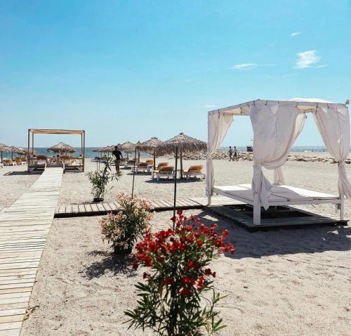 a tent and flowers on a beach with umbrellas at Boutique Citadel in Eforie Nord
