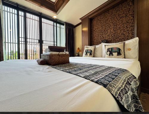 a bedroom with a large bed and a large window at Wannamas Chiangmai Boutique House in Chiang Mai