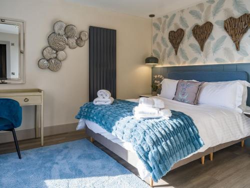 a bedroom with a blue bed with towels on it at Arran Shores Suite 10 in Lamlash