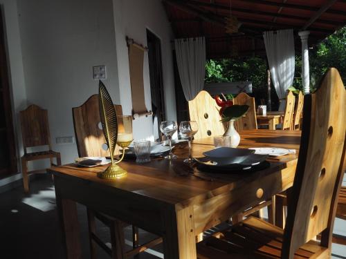 a wooden table with wine glasses and a lamp on it at Villa Lyvie ayurvedic hotel in Tangalle