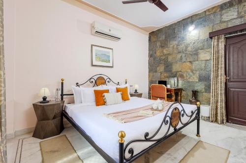 a bedroom with a bed and a stone wall at Alaya Stays 2 BHK With Garden & Outdoor Area - Abhimanyu Mansion Topaz in Udaipur