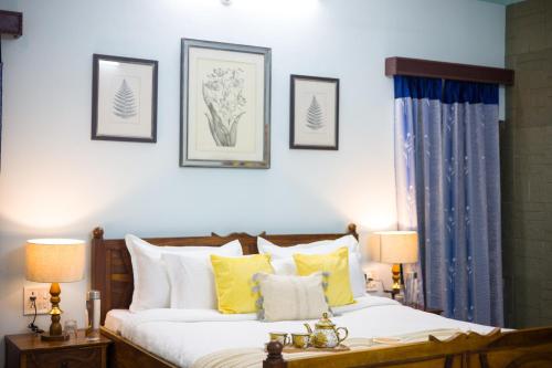 a bedroom with a bed with yellow and white pillows at Alaya Stays 2 BHK With Garden & Outdoor Area - Abhimanyu Mansion Topaz in Udaipur