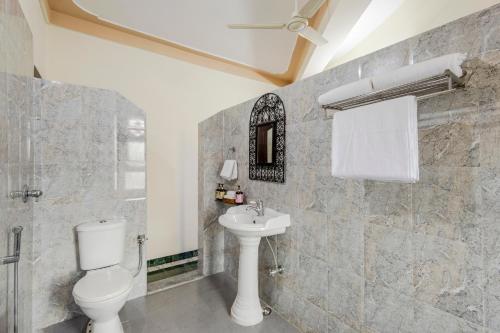 a bathroom with a toilet and a sink at Alaya Stays 2 BHK With Garden & Outdoor Area - Abhimanyu Mansion Topaz in Udaipur