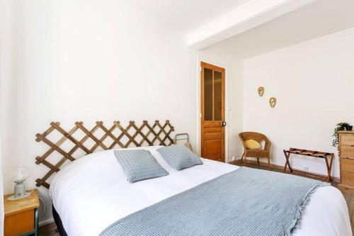 a bedroom with a large white bed with two blue pillows at Le Fidésien in Sainte-Foy-lès-Lyon
