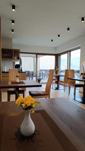 Una sala de estar con un jarrón con flores sobre una mesa. en Highlight Apartments, en Appiano sulla Strada del Vino