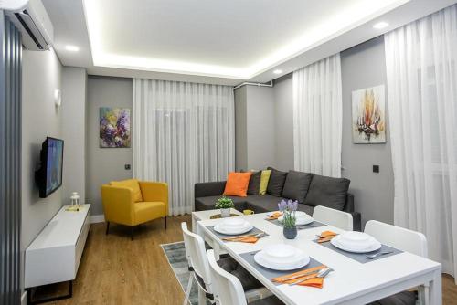 a living room with a white table and a couch at Stile Suite Family Hotel in Antalya