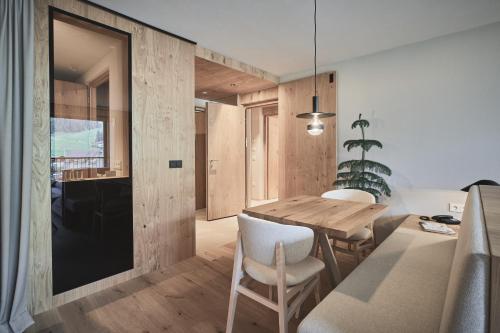 a kitchen and dining room with a wooden table and chairs at AMA Stay in San Vigilio Di Marebbe
