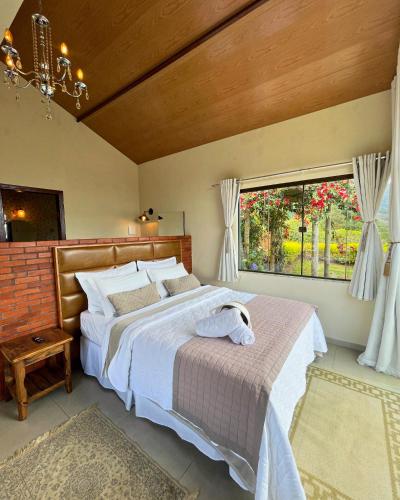 a bedroom with a large bed and a window at Mirante das Montanhas in Pedra Menina