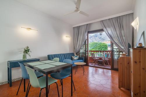 Una sala de estar con mesa de comedor y sillas. en PARAISO BAMBOO - 2 bedrooms, 2 bathrooms, fibre net, heart of the Los Gigantes, tv channels, en Acantilado de los Gigantes