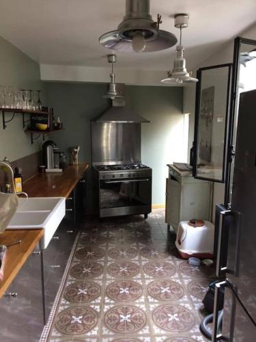 une cuisine avec une cuisinière et un évier dans l'établissement Charmante maison 2 terrasses à 5 mins du métro, à Bagnolet