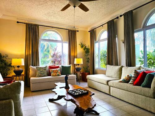 a living room with two couches and a table at Mais Oui Villa in Discovery Bay