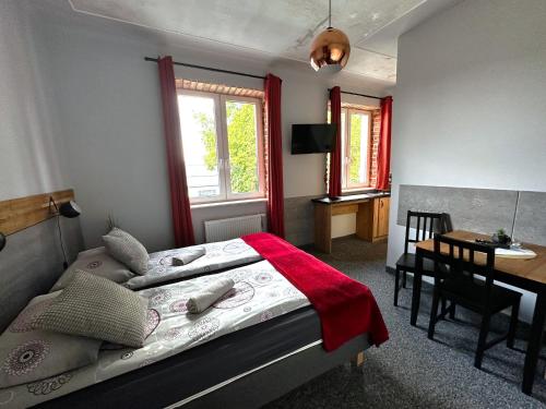 a bedroom with a bed and a table and a desk at Apartamenty Rycerskie in Inowłódz