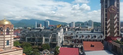 a view of a city with a clock tower and buildings at Schöne Wohnung mitten im Zentrum von Batumi in Batumi