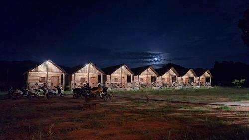 a row of houses at night with motorcycles parked in front at Hampi One Love in Hampi