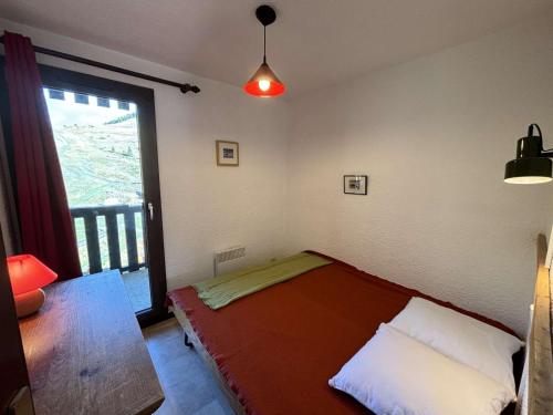 une chambre avec un lit dans une chambre avec une fenêtre dans l'établissement Appartement confort 3 pièces cabine skis aux pieds, balcon, 6 personnes - Auris en Oisans - FR-1-297-27, à Auris