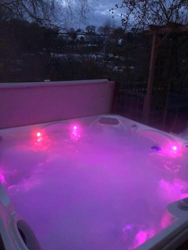 a hot tub with pink lights in a backyard at Middle Wicket in Newton Abbot
