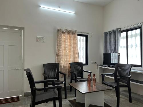 a living room with chairs and a table and a desk at HOMESTAY - AC 1 BHK NEAR AlRPORT in Chennai
