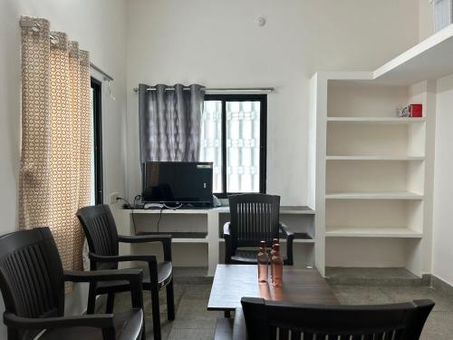an office with chairs and a desk with a computer at HOMESTAY - AC 1 BHK NEAR AlRPORT in Chennai
