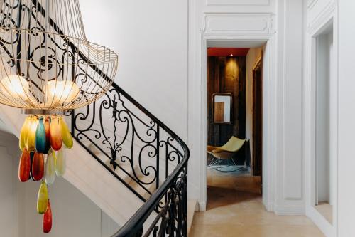 a hallway with a staircase with a chandelier at Hôtel Domaine de Biar in Montpellier