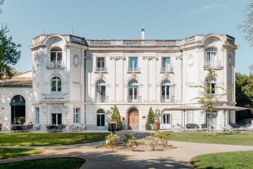 a large white building with a courtyard in front at Hôtel Domaine de Biar in Montpellier