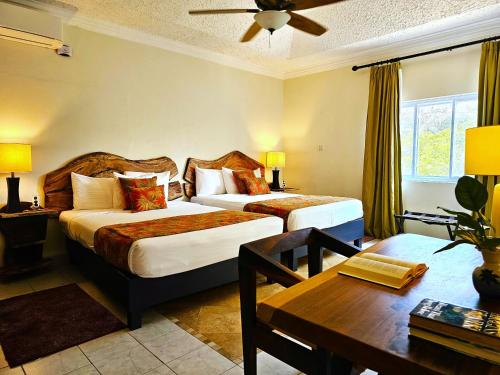 a hotel room with two beds and a table at Mais Oui Villa in Discovery Bay
