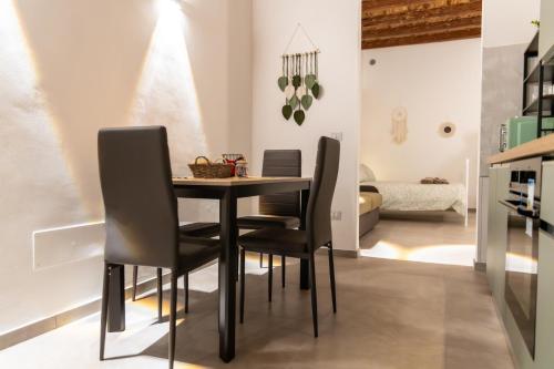 a dining room with a black table and chairs at Il Girasole in Barletta