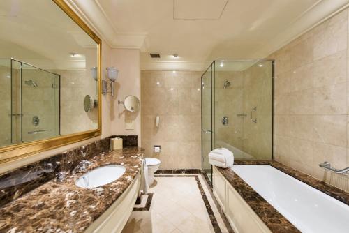 a bathroom with a tub and a sink and a shower at Treasury Brisbane in Brisbane