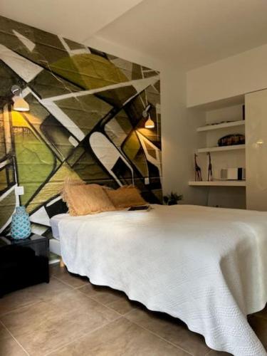 une chambre avec un lit blanc et un tableau au mur dans l'établissement Villa Standing Palombaggia 10 personnes vue mer, piscine, à Porto-Vecchio