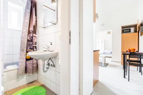 La petite salle de bains est pourvue d'un lavabo et d'un tabouret vert. dans l'établissement Apartments Mönchengladbach, à Mönchengladbach