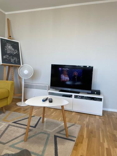 a living room with a tv and a coffee table at Dziesiąte Piętro in Poznań