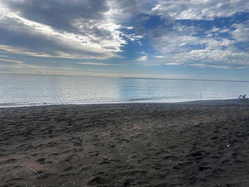 a beach with a cloudy sky and the ocean at Appartamento Grande Taty in Ladispoli