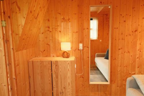 a room with wooden walls and a table with a lamp at Múlafossur Cottages by famous waterfall in Gásadalur in Gásadalur