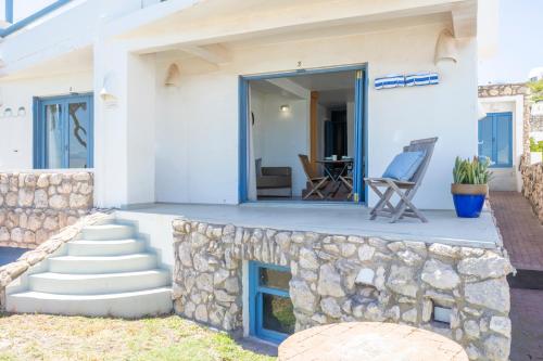 a house with a stone wall and stairs to a patio at Speelhuis Collection in Langebaan