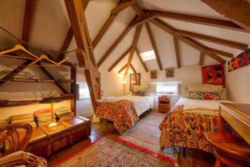 een slaapkamer met twee bedden en een kamer met balken bij Adore Portugal Coimbra Guest House in Coimbra