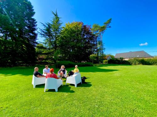a group of people sitting in chairs on the grass at La Demoiselle ô Bois - Gîte nature et confort aux portes de Chimay in Seloignes