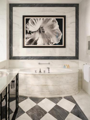 a bathroom with a tub with a picture of a flower at Baur au Lac in Zürich