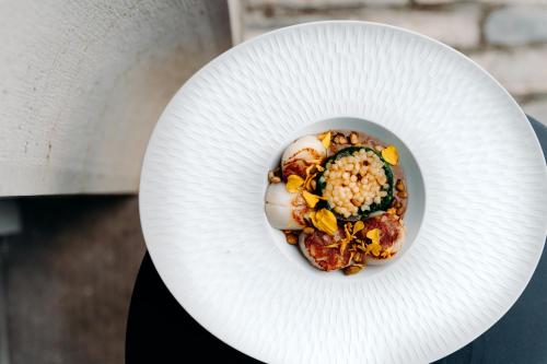 a person holding a white plate with food on it at Hôtel Domaine de Biar in Montpellier
