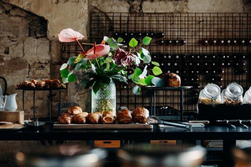 a table with a vase filled with flowers and pastries at Hôtel Domaine de Biar in Montpellier