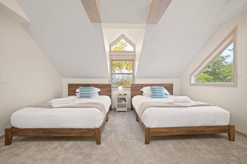 three beds in a room with two windows at Farmhouse 1918 Grand Retreat for 12 people with Lake Views in Boyne City
